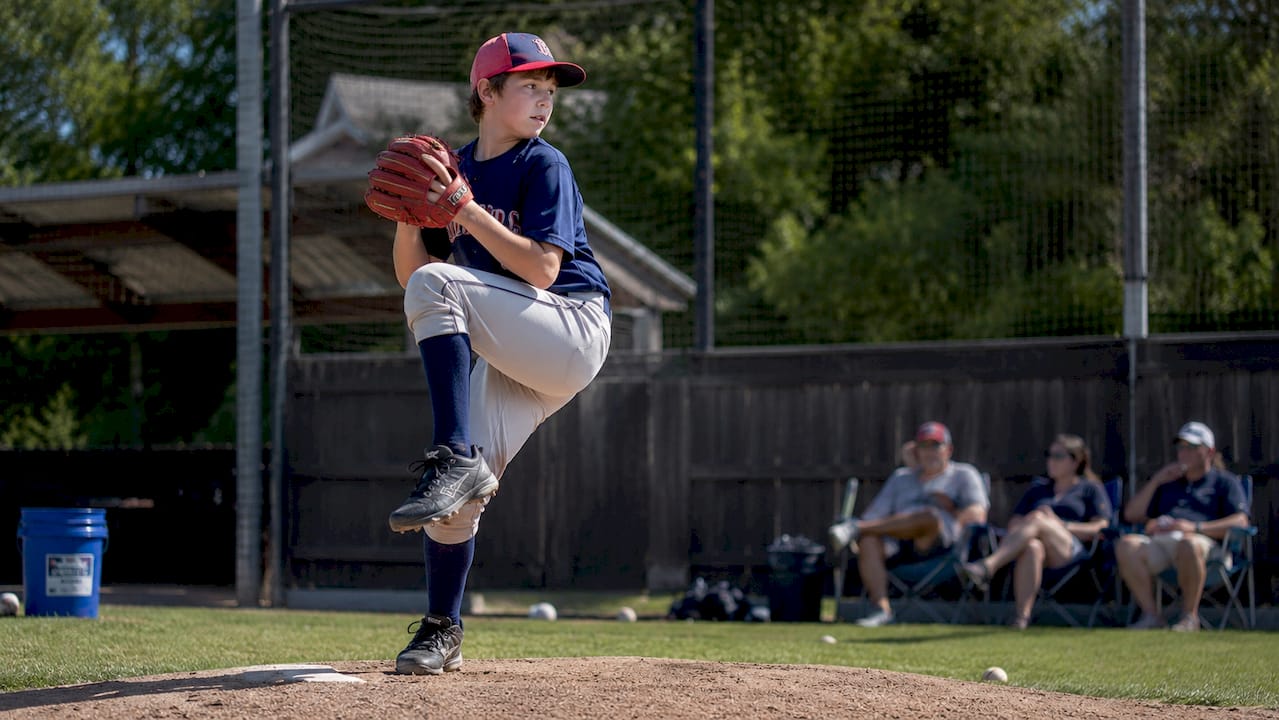 Youth baseball pitcher preparing to throw a pitch