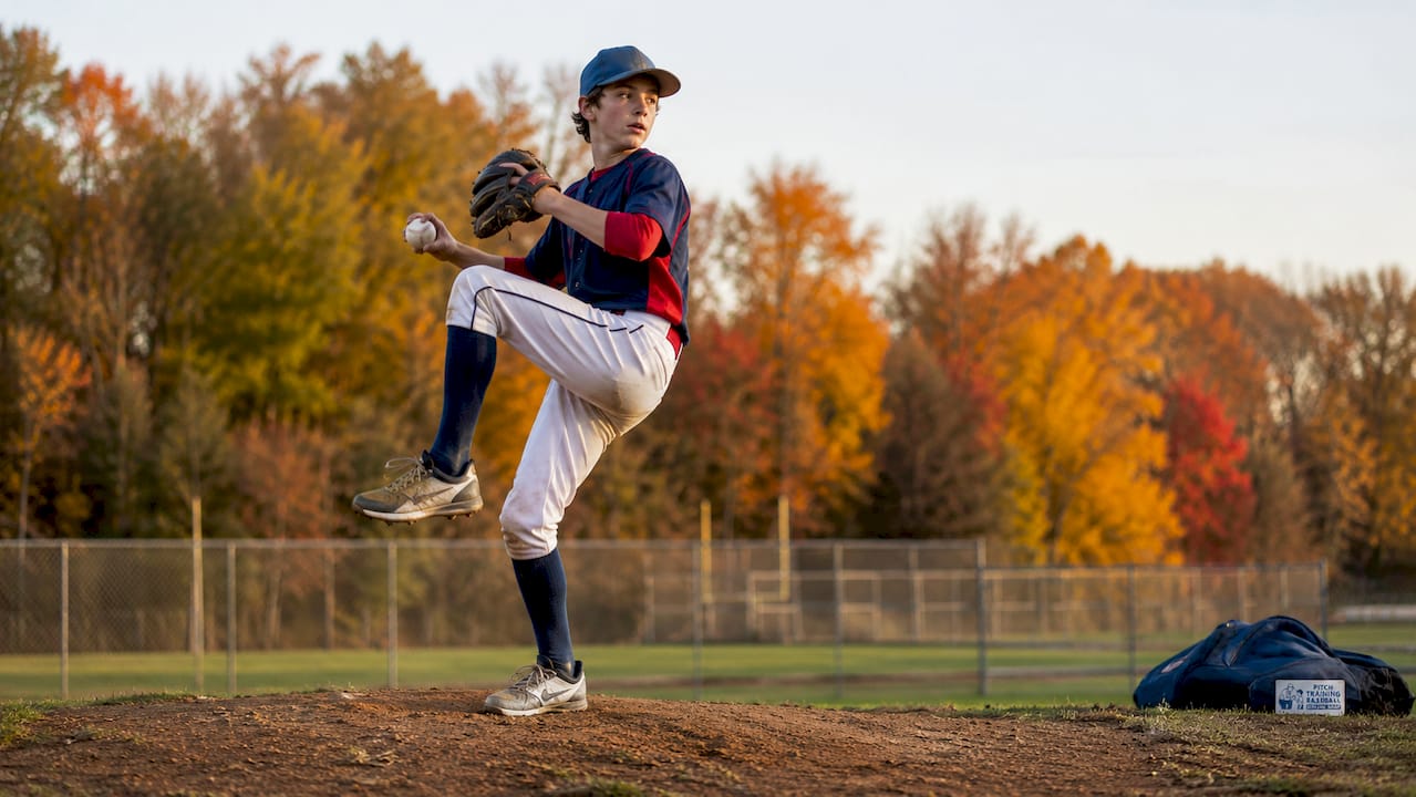 Young baseball pitcher demonstrating pitching posture outdoors