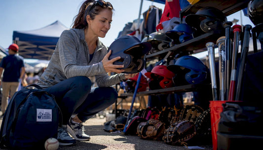 Parent inspecting youth sports helmet in store