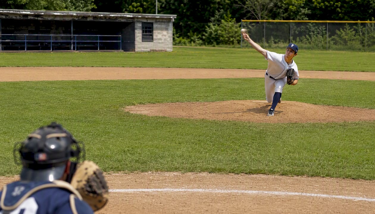 Baseball pitcher throwing slider pitch on field