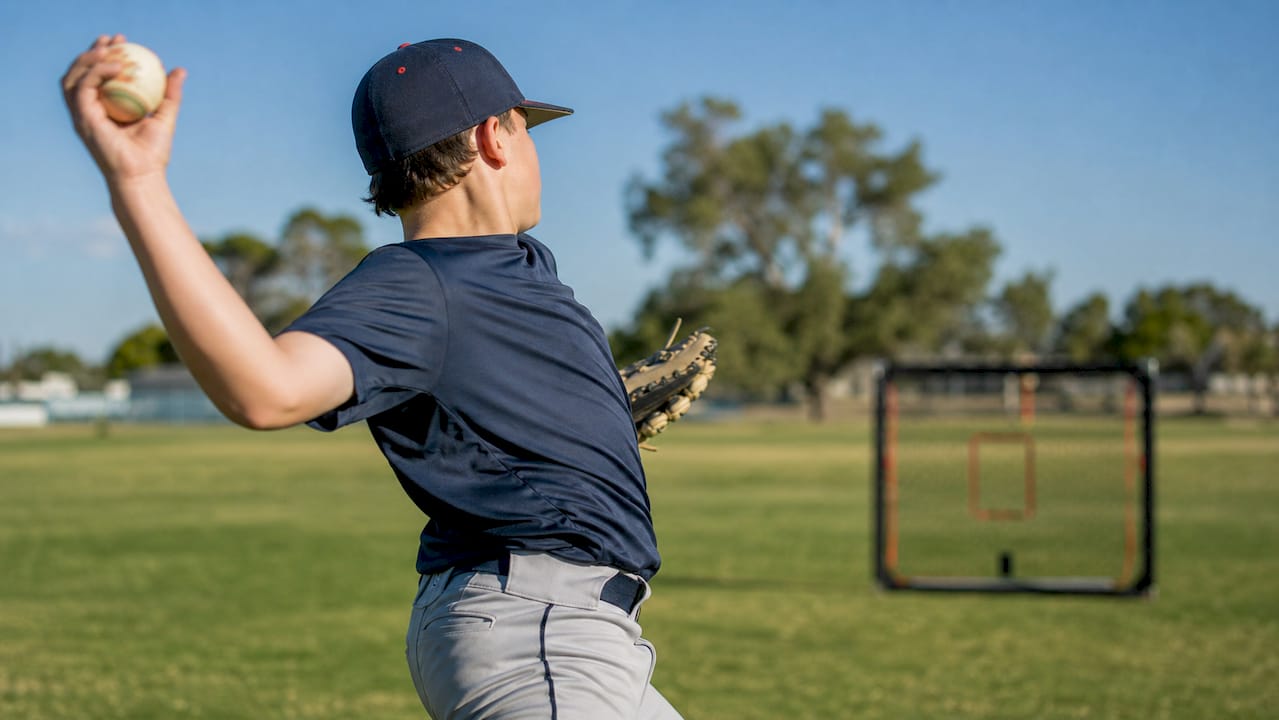 Youth baseball pitcher throwing on field
