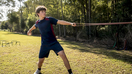 Youth pitcher doing arm strength exercise indoors