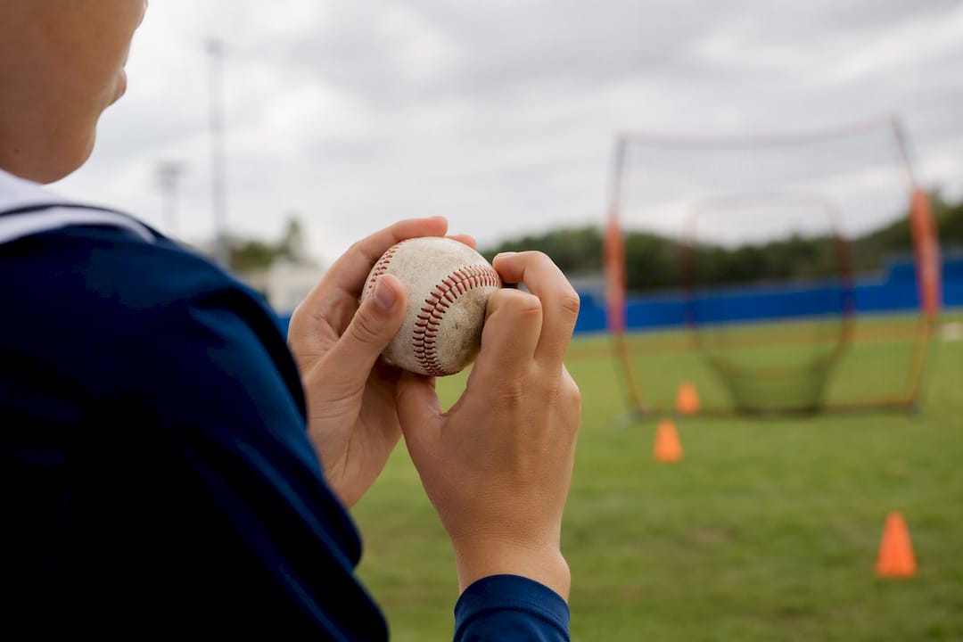 Youth hand adjusting baseball grip outdoors