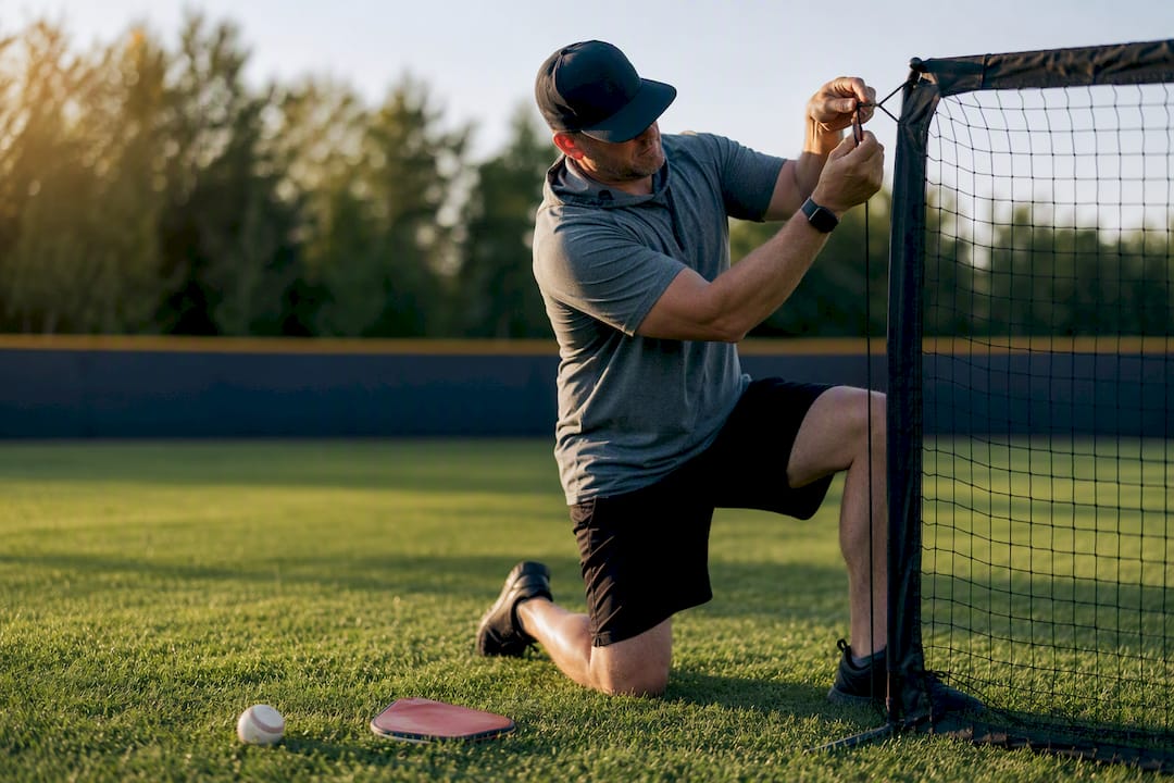 Coach assembling a youth pitching net