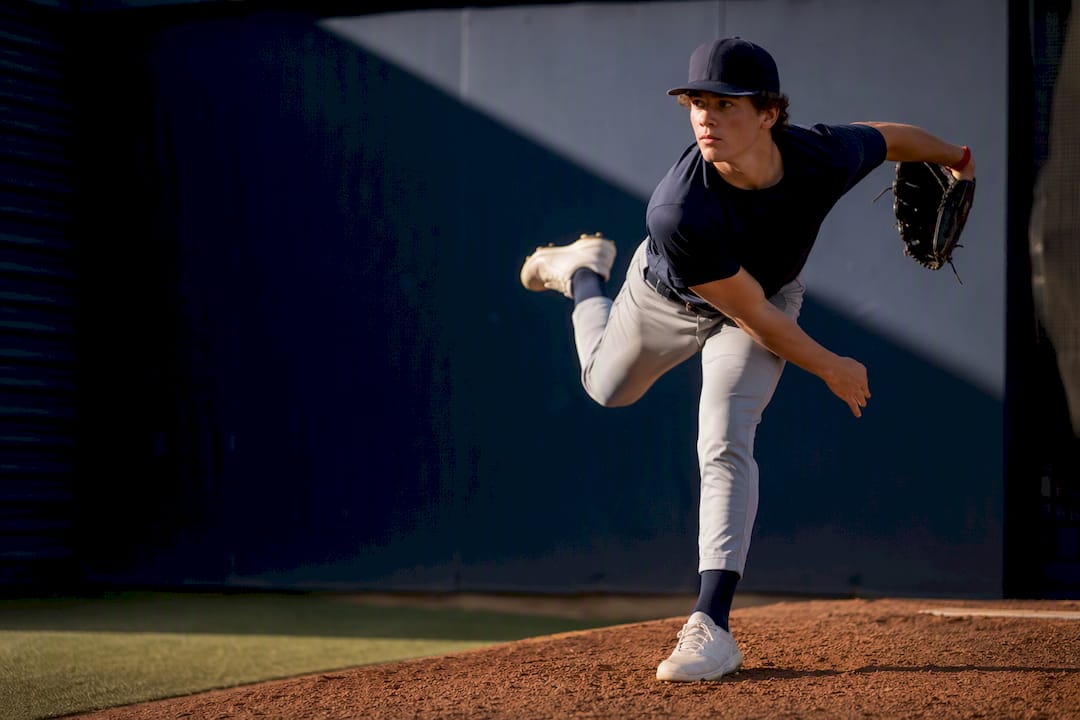 Left-handed youth pitcher finishing a delivery