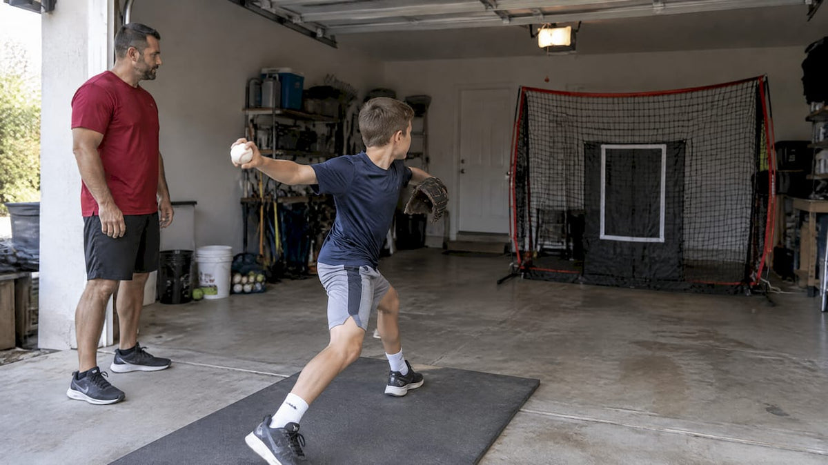 Youth pitcher practicing safely inside garage