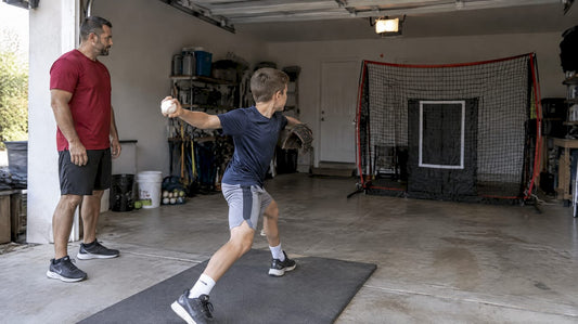 Youth pitcher practicing safely inside garage
